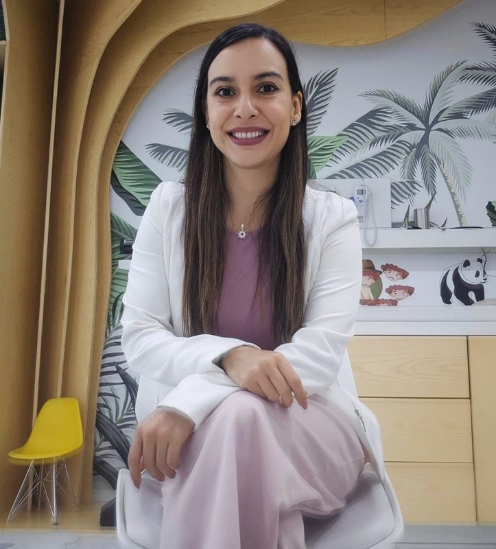 Perla sentada en su consultorio, sonriendo.